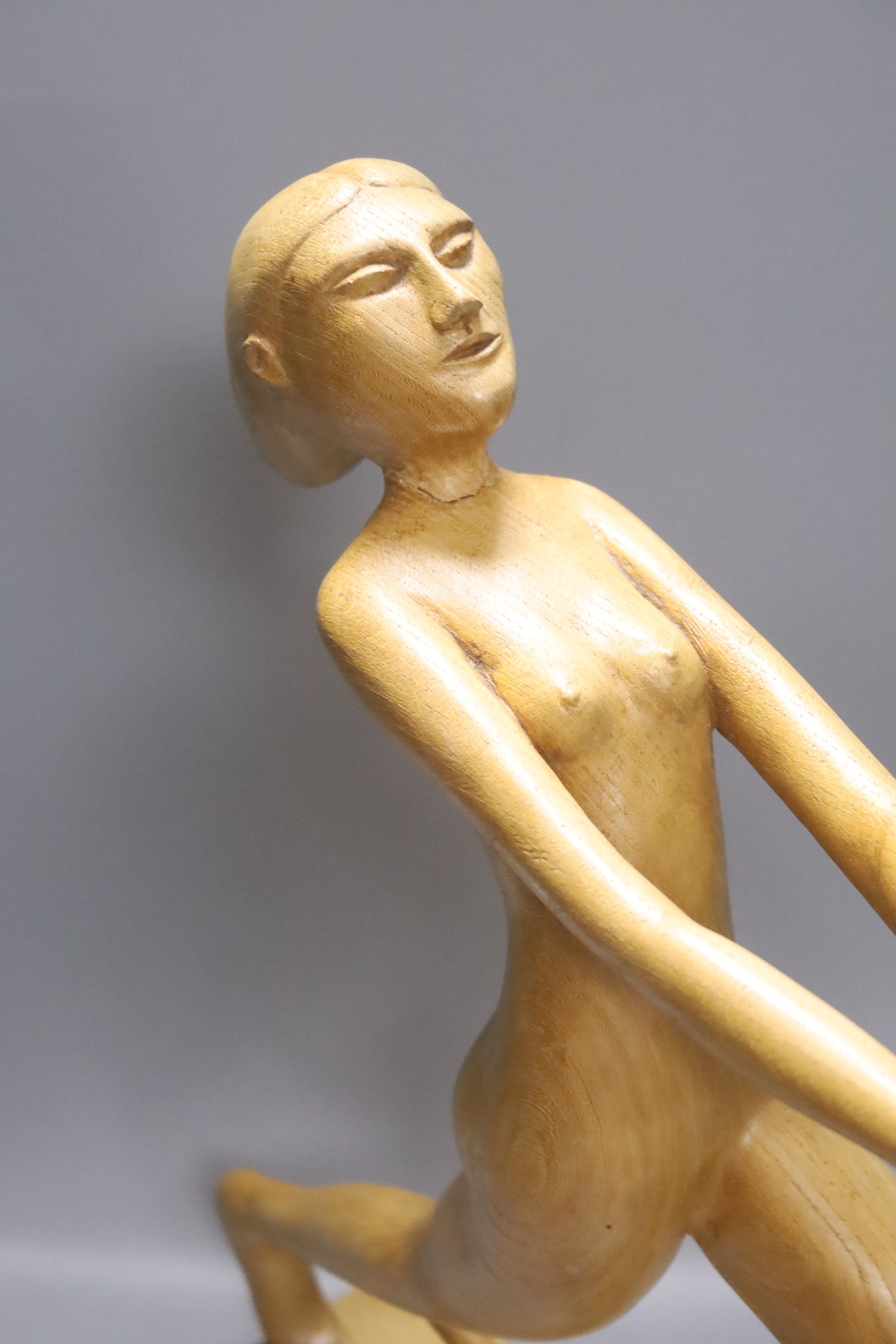 An Art Deco style light elm carving of a woman and dog on lead-weighted plinth, height 40cm